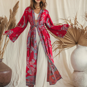 Woman in red floral kimono robe with wide sleeves, styled with white pants and gold choker, boho chic aesthetic